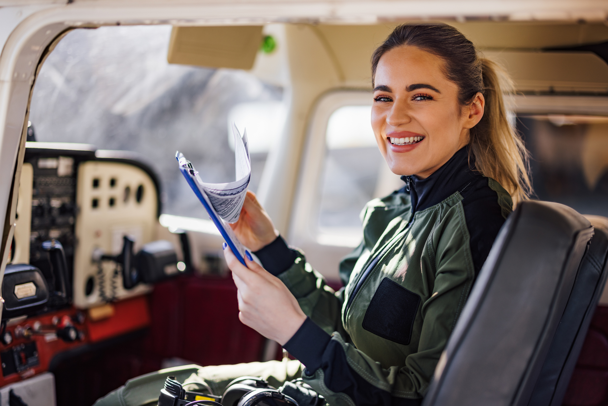 Portrait of a smiling female pilot, posing for the camera.
